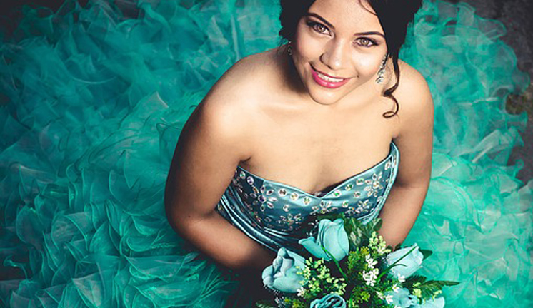 Happy Hispanic Or Latina Girl Wearing A Quinceanera Dress And Holding Flowers At Quinceanera Venue