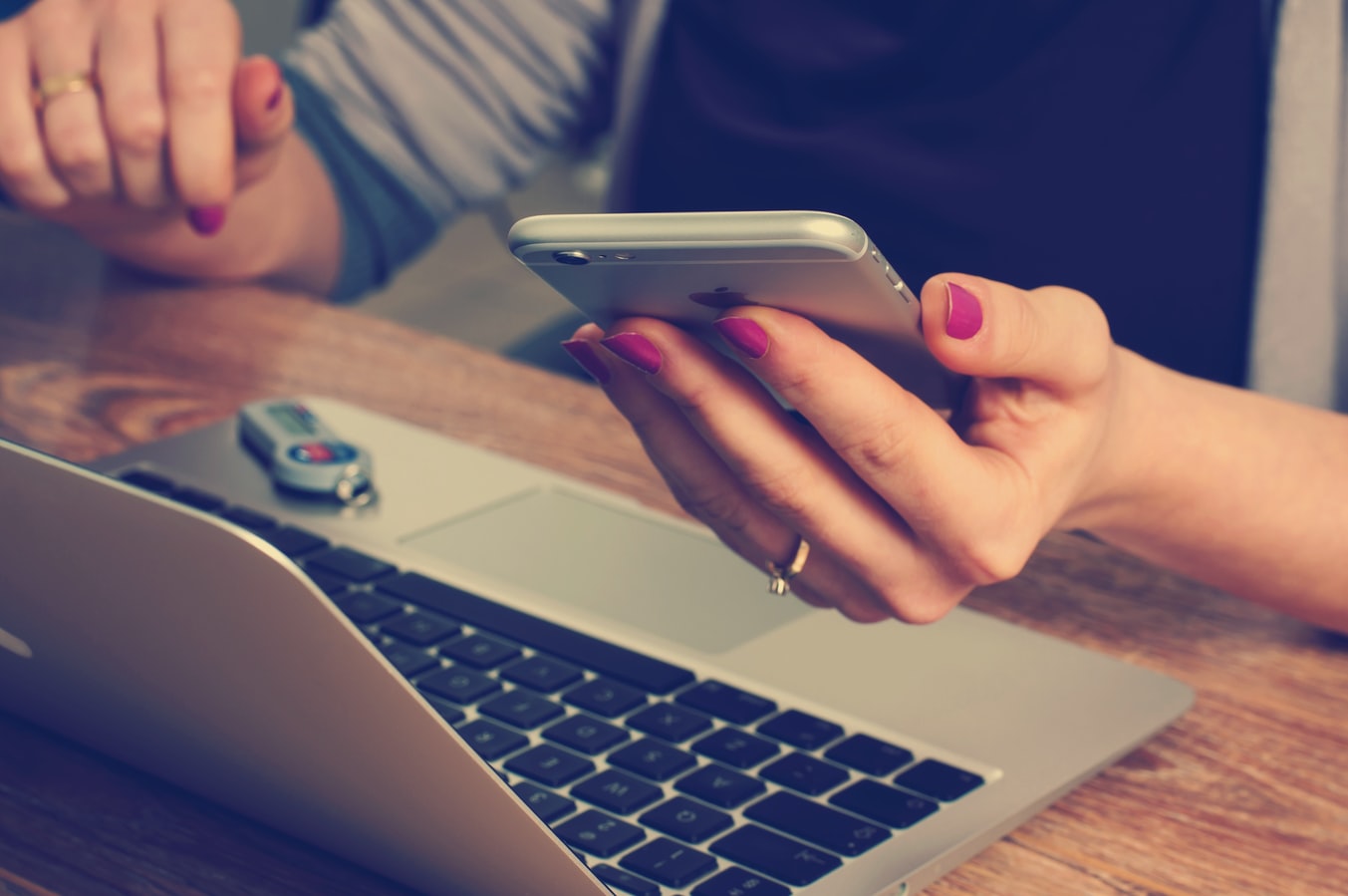 Wedding Planning Tips - Digital RSVP - Woman Holding Phone And Working On Laptop